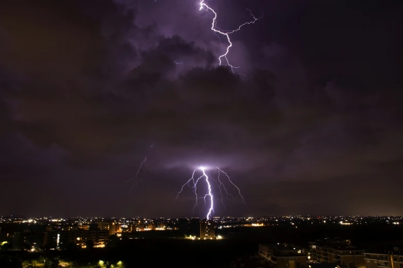 purple lightning is seen in the night sky over a city
