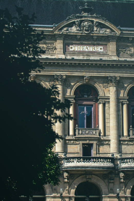 an old building that has columns, windows, and an iron sculpture