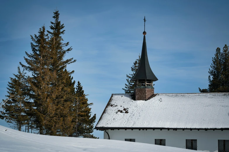 a house in a snowy field with trees around