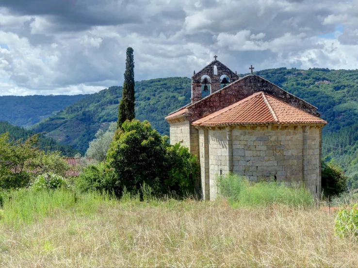 the building sits next to a tree and hill