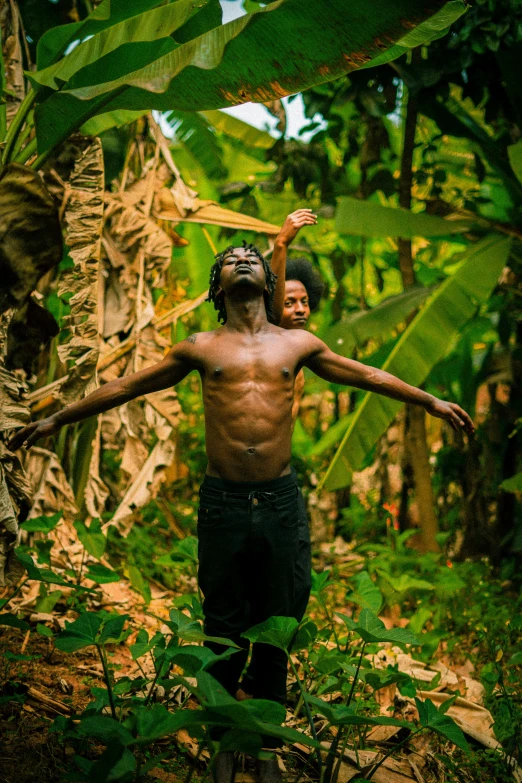 an african american child playing with a stick in a jungle