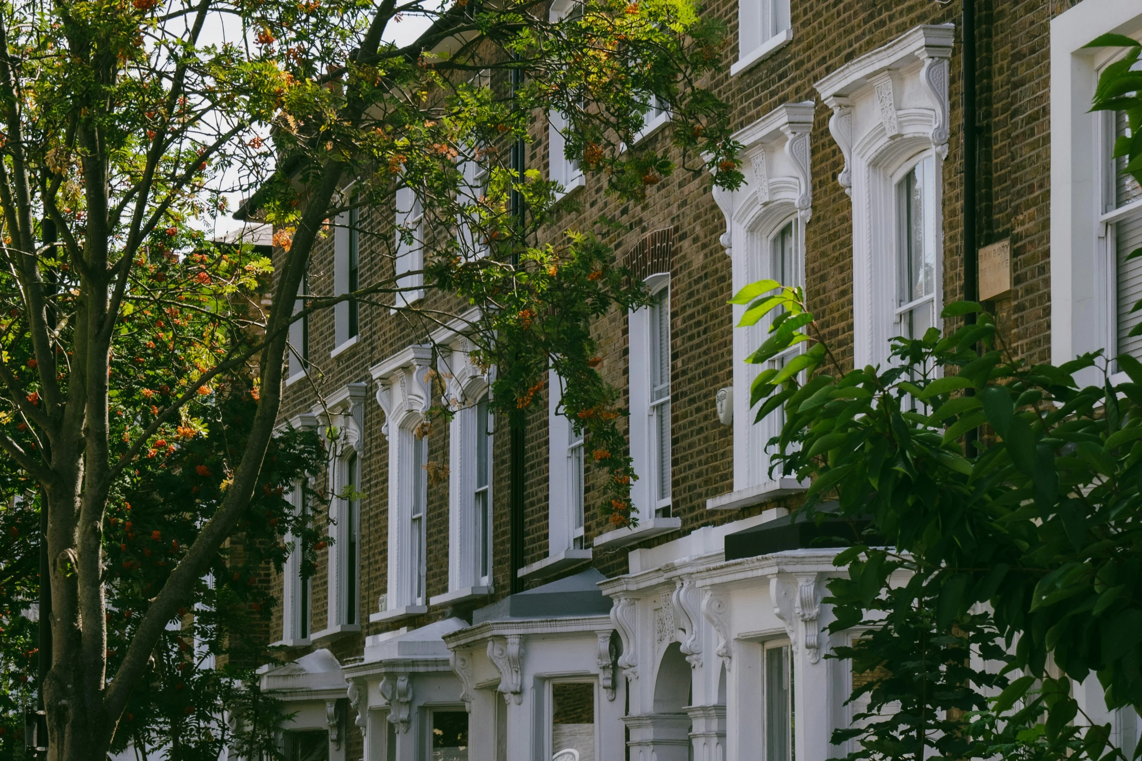 a row of white and brick townhouses in the evening