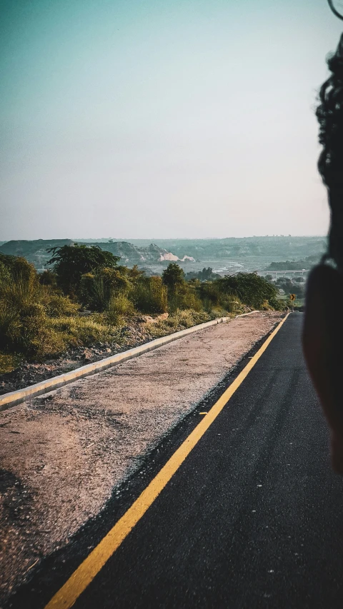 a woman taking a po on the side of the road