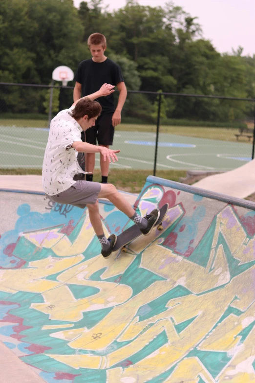 the two boys are skateboarding on a colorful ramp