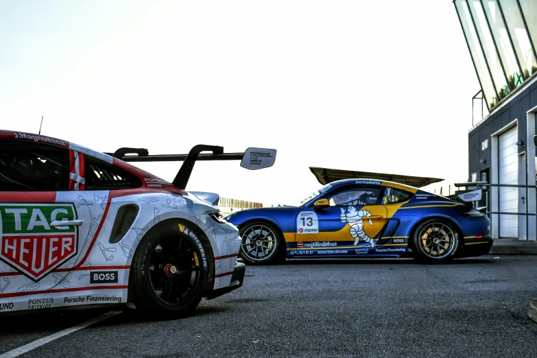 two race cars parked in front of each other in a parking lot