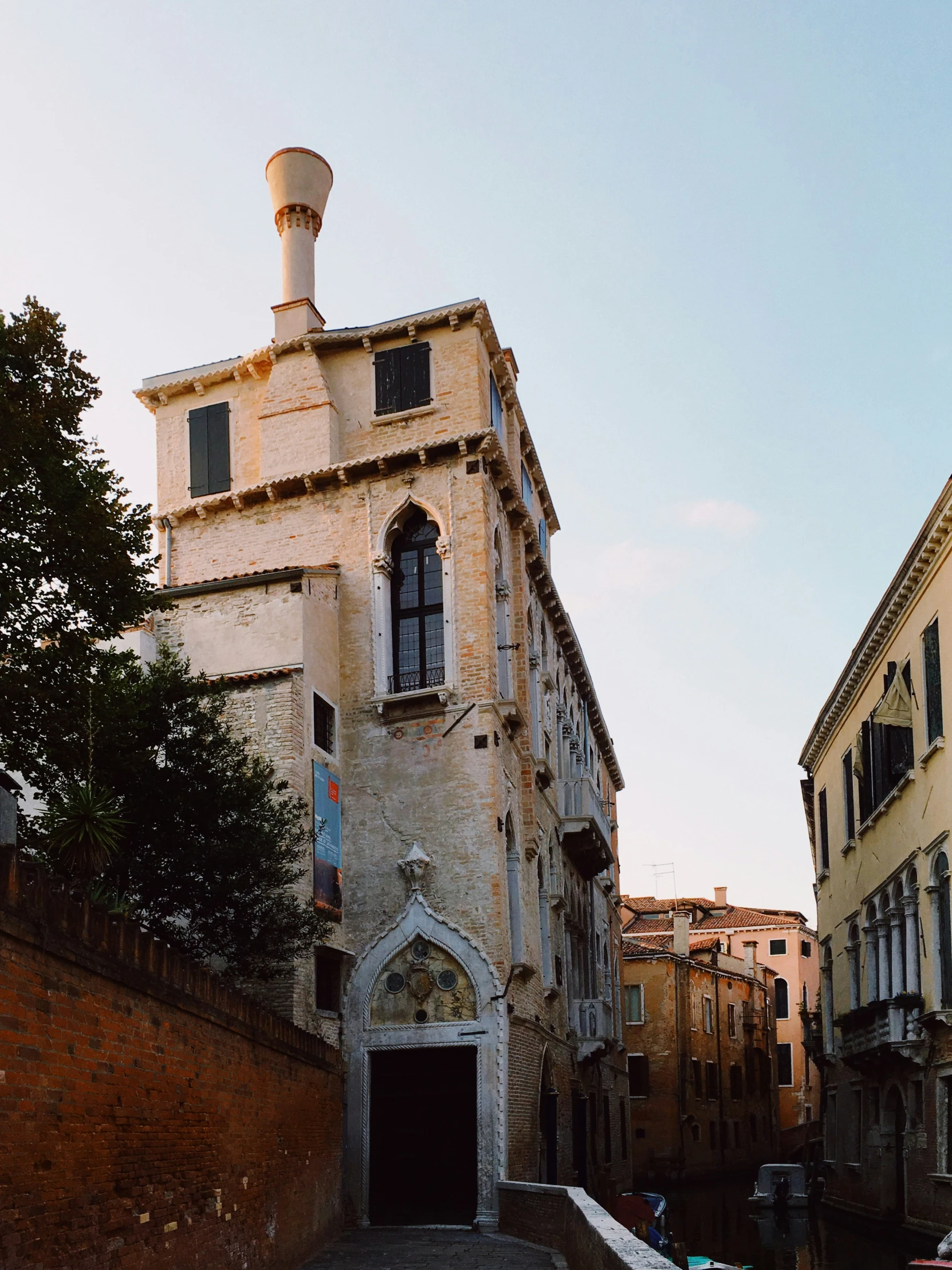 a tall white building sitting next to a very tall brown wall