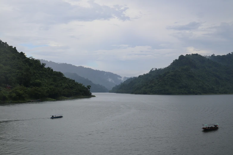 three boats floating on top of a large lake