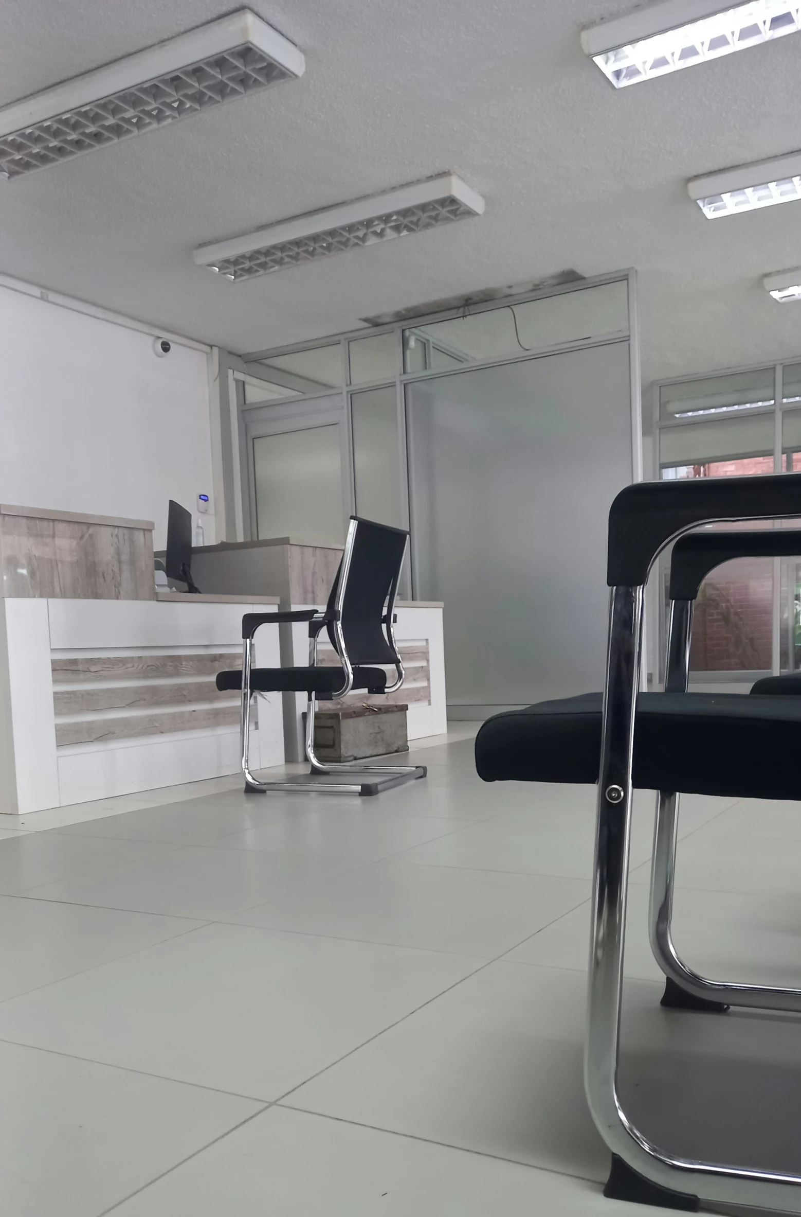 an empty office room with black chairs in the middle