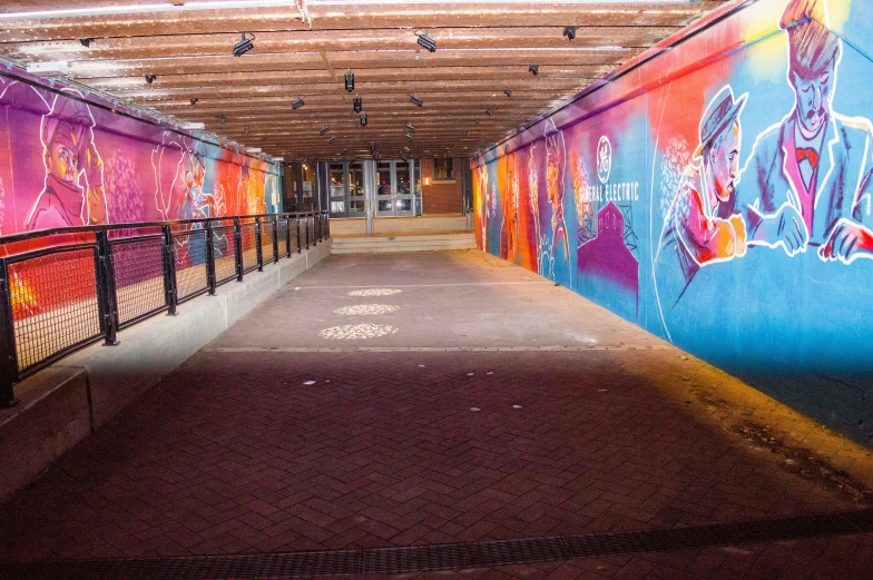 an empty walkway with graffiti on the walls