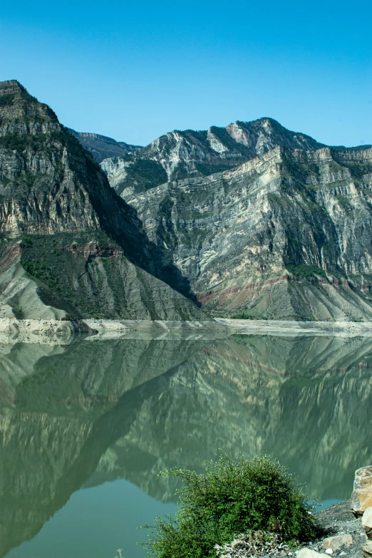 the mountains rise above a body of water in front of the trees