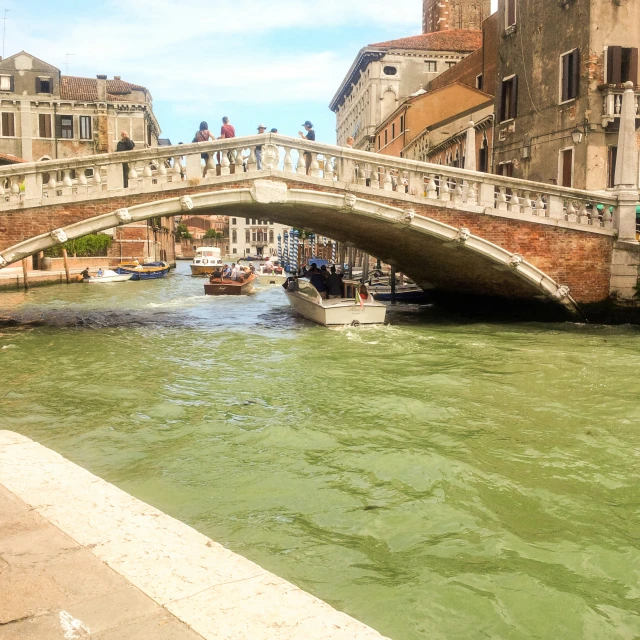 a boat traveling through a canal under a bridge