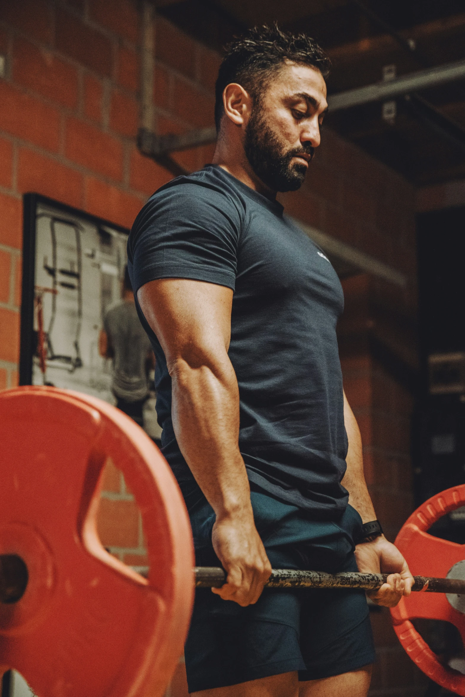 a man at the gym doing an incline on a barbell