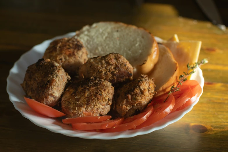 a white plate topped with meatballs, carrots and bread