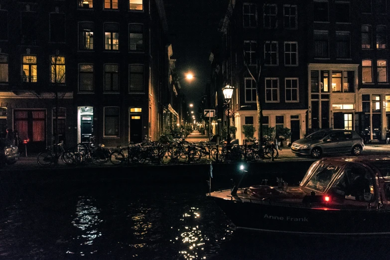 a nighttime s of buildings, boats and a canal