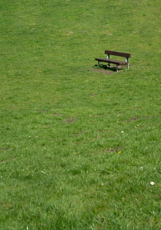 a park bench sitting on top of a grass field