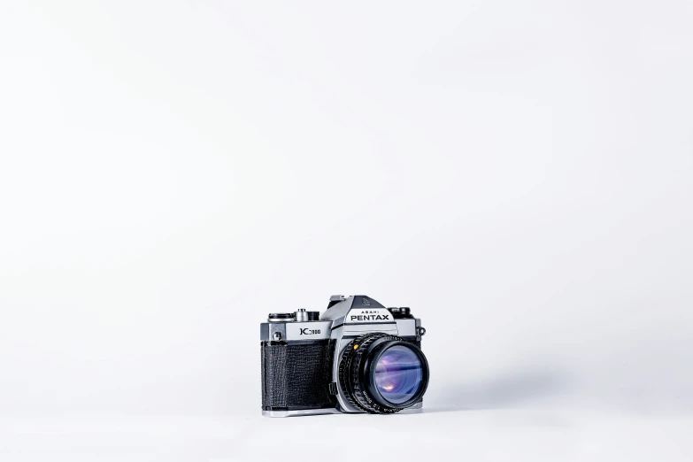 a digital camera on a white surface taken by someone with an eos lens