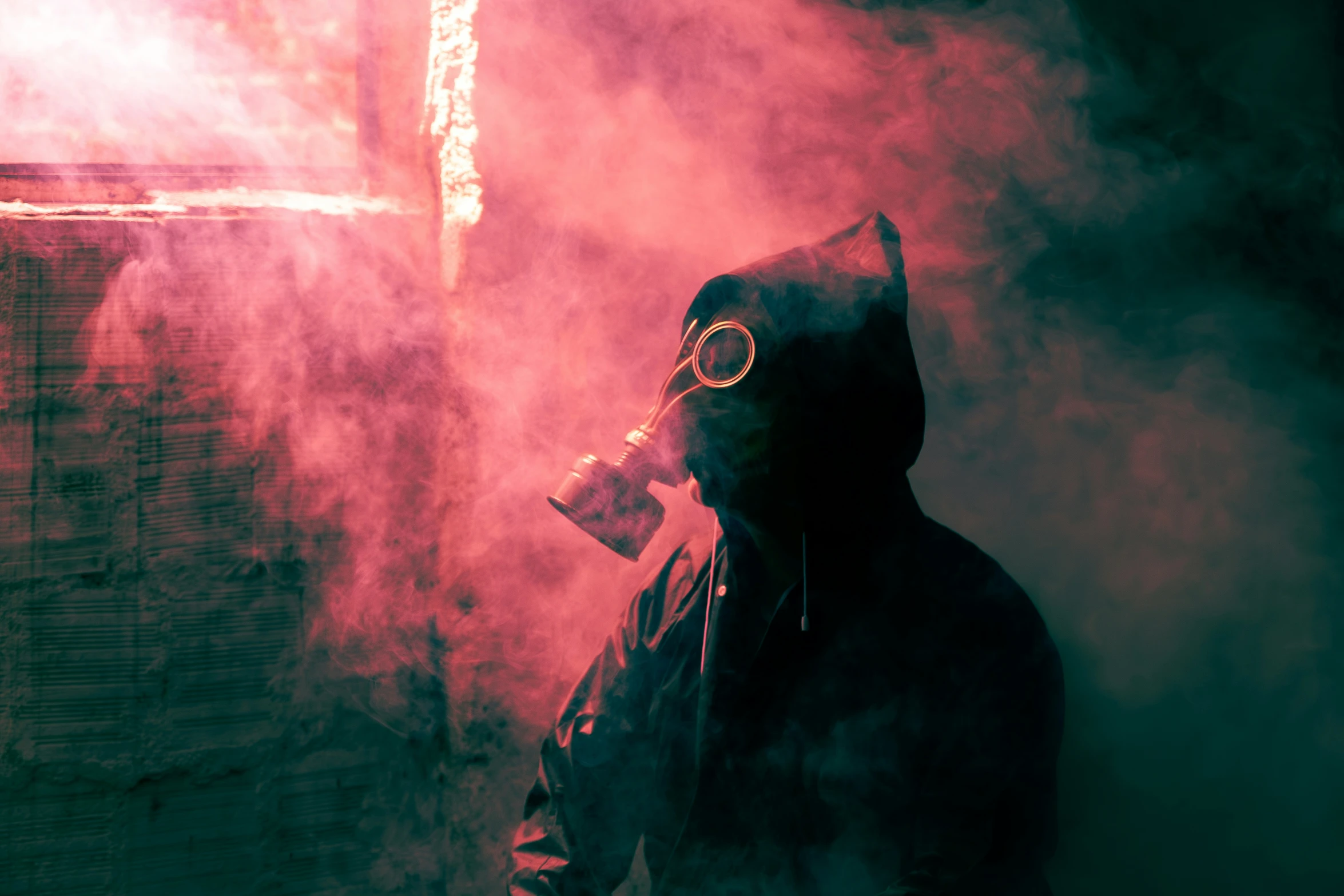 a man standing in smoke with a gas mask on