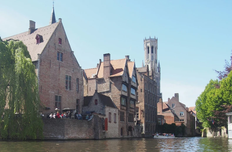 the people are standing on a river edge watching what appears to be a castle