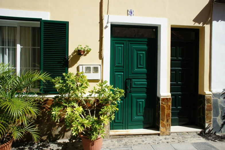 a large green door sitting in front of a green building