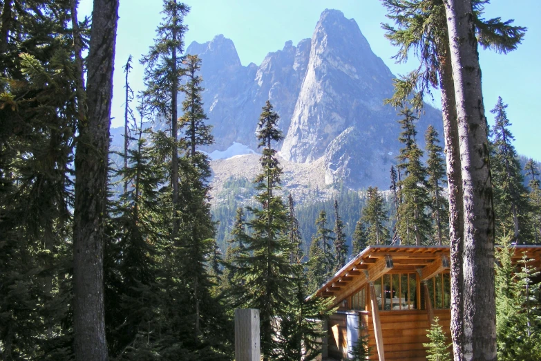 a house that is in the grass next to a mountain