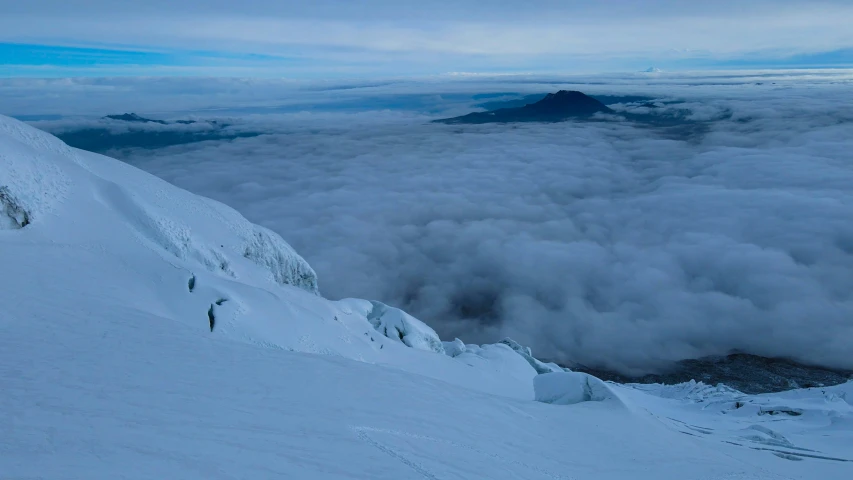 there is a snowy mountain covered in clouds