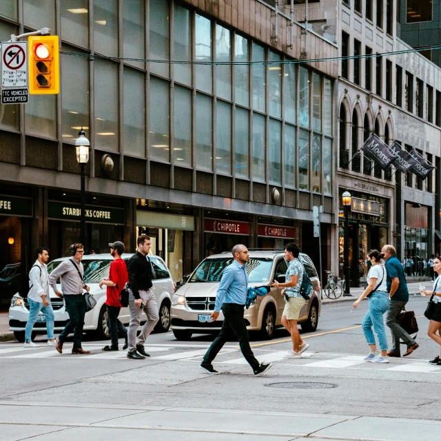 a bunch of people crossing the street in traffic