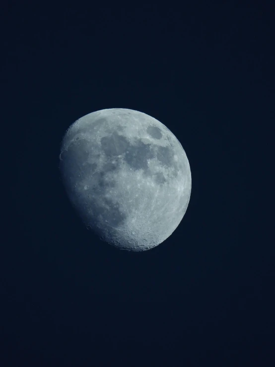 a large round blue moon with the moon on a dark night