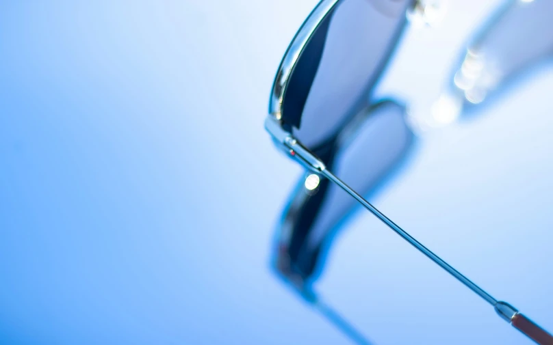 two silver rimmed sunglasses under the blue sky