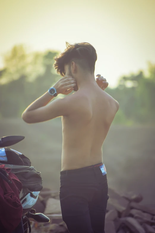 a man standing next to a motorcycle in a field