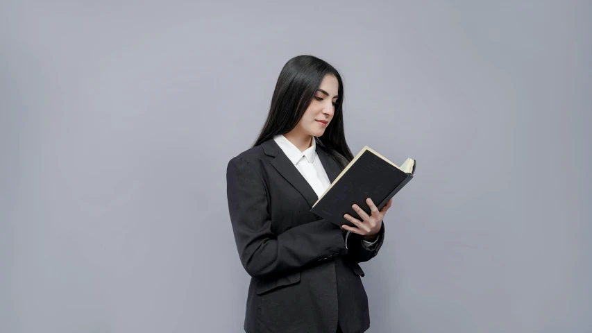 a girl in a suit and tie holding a folder