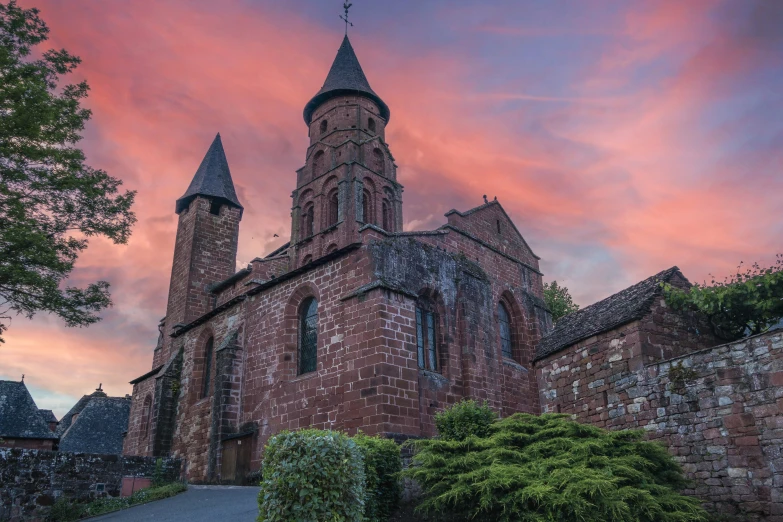 an old brick building with steeples against a purple sky