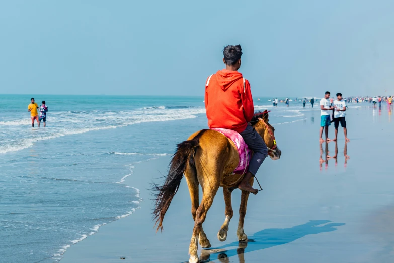 there is a man riding a horse on the beach