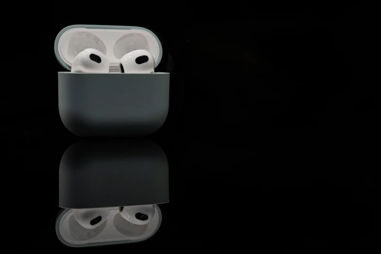 an airpods is opened in a case on a black surface