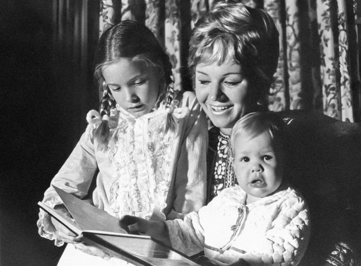 a woman and two little girls are on the telephone