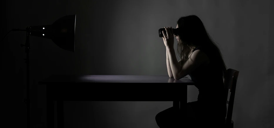 a woman with long hair sitting in a chair in front of a desk