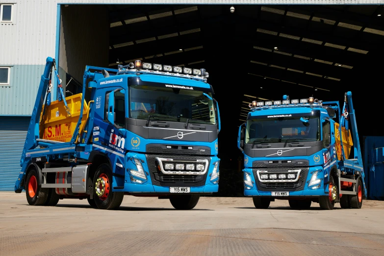 two large blue truck are parked in a garage