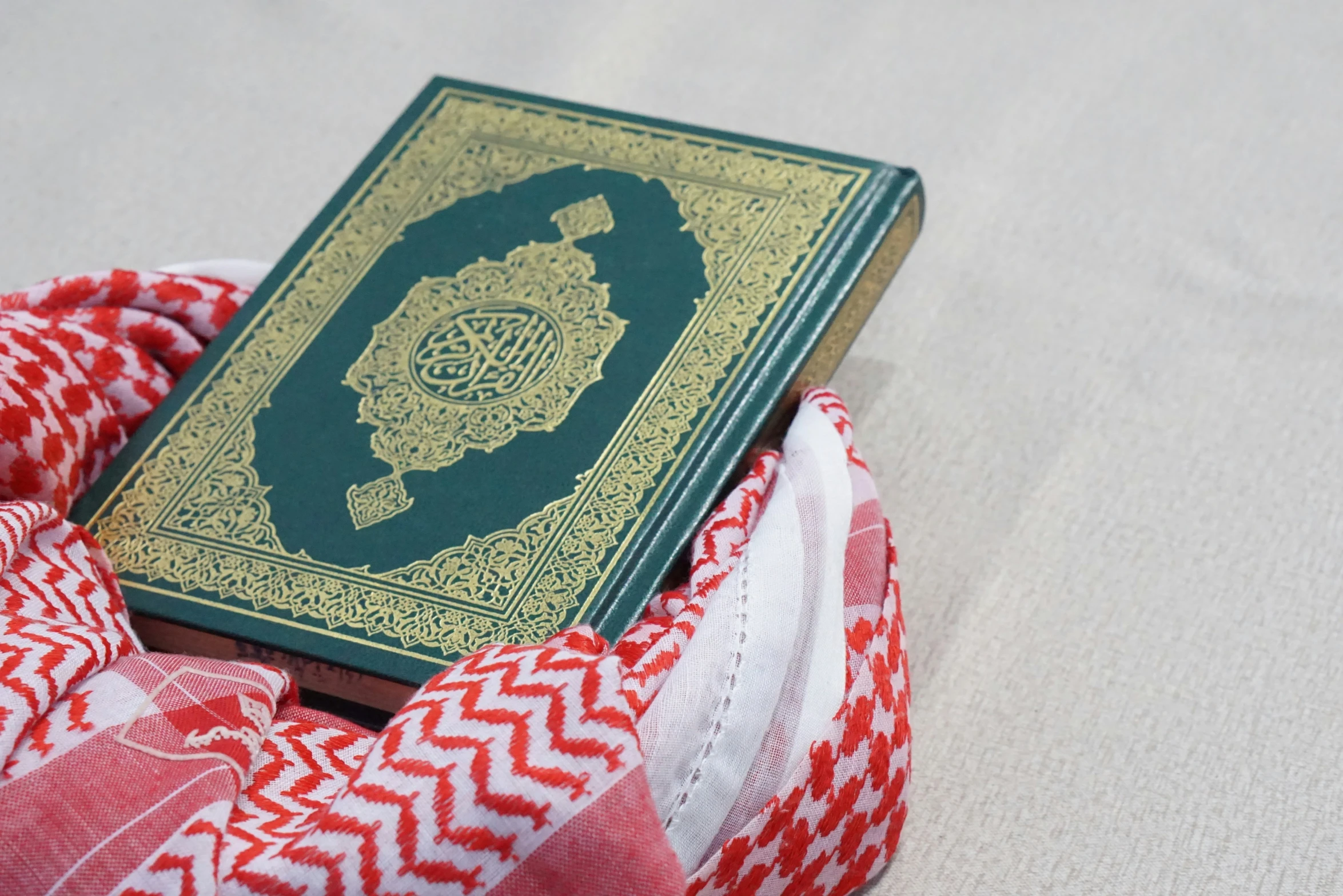 a green book on top of a red and white fabric