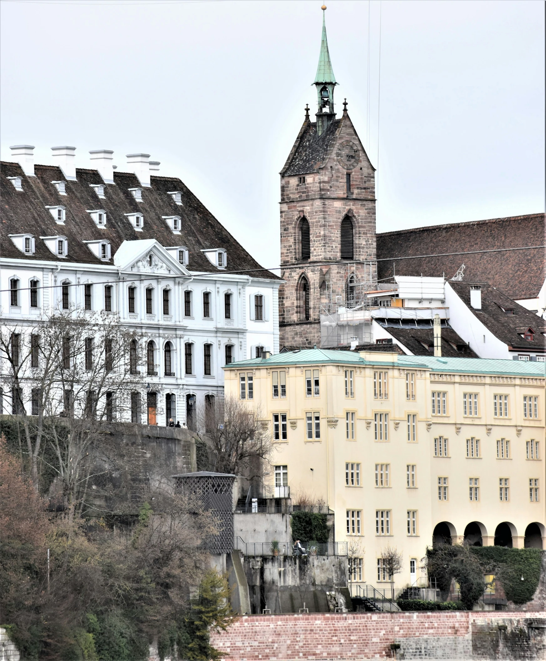 a city with several large buildings, one with a steeple and one with a large clock tower