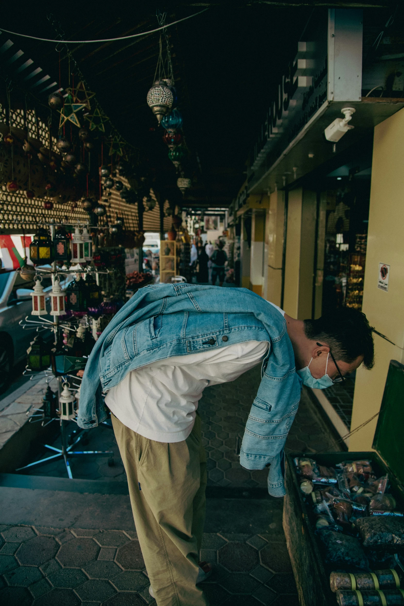 a man leaning on his shirt as he looks at things on display