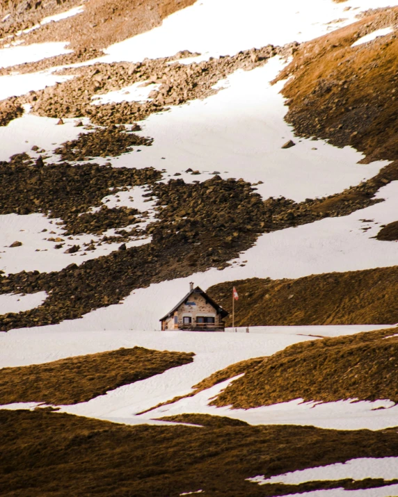 a house nestled among the mountains in winter