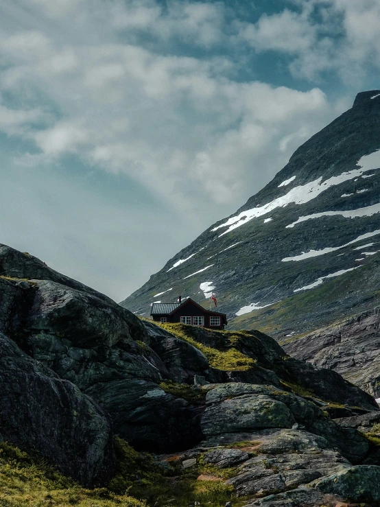 a single cabin on top of a rocky hillside