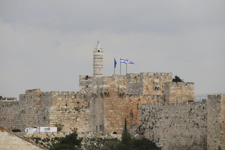 a stone wall with flags on top of it