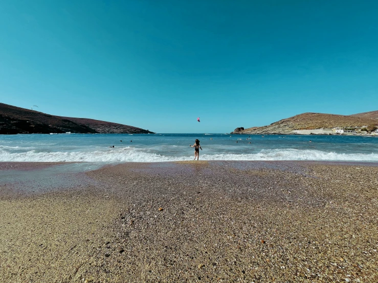 a person walking along a sandy shore line