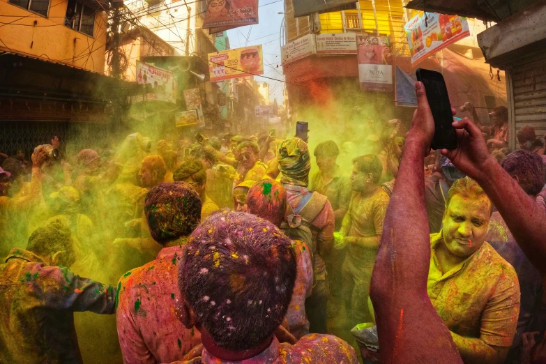 a group of people covered in colored powder playing with each other