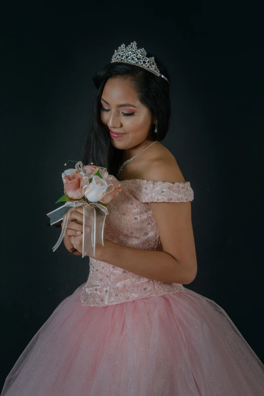 a woman wearing a pink ball gown and a tiara