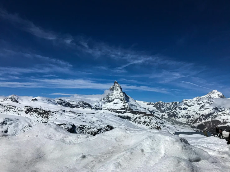 a mountain with snow on the ground and mountains in the background