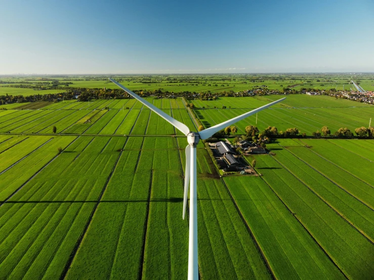 aerial view of a wind farm with a house and wind turbine