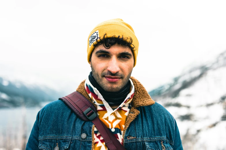 the young man wears a jacket and scarf on his head