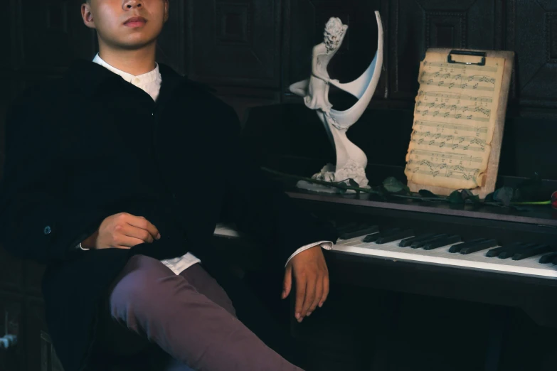 the man is posing for a pograph in front of his piano