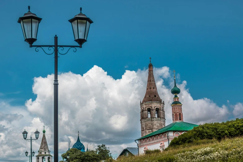 a large clock tower sits under a blue cloudy sky